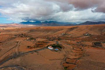 Aerial view of arid Fuerteventura landscape with isolated rural house surrounded by dramatic...