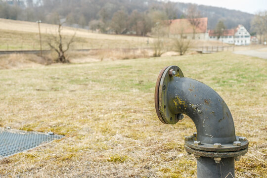 Metall-Anschlussrohr mit Kr&uuml;mmung und Muttern auf Wiese im Lautertal