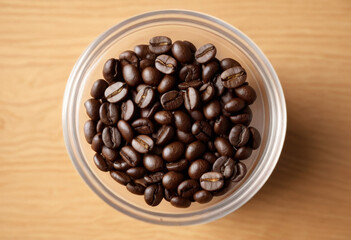 Fototapeta premium Put the roasted coffee beans directly in the container on the table