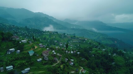 Fototapeta premium Aerial view of serene mountainous village landscape with misty hills and scattered houses in the background