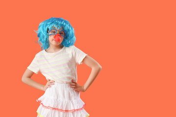 Funny girl with colorful wig and clown nose on orange background. April Fool's Day celebration