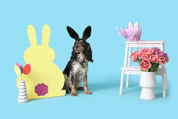Cute cocker spaniel in bunny ears with beautiful tulips, Easter paper eggs and rabbit on blue...