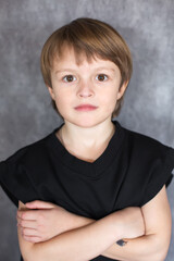 Portrait of a handsome blond boy with big brown eyes wearing a black sweatshirt