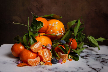 Top view of oranges and tangerines with flowers and leaves, on white marble, horizontal, with copy space