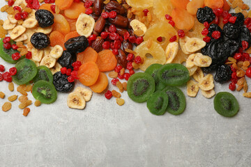 Mix of different dried fruits on grey table, top view