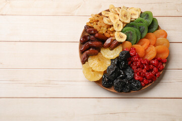 Different dried fruits on white wooden table, top view. Space for text