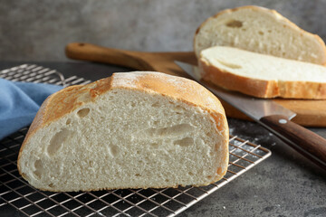 Cut fresh bread and knife on grey table, closeup