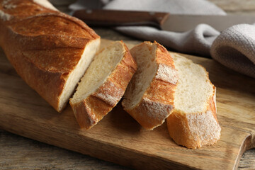 Pieces of fresh baguette on wooden table, closeup