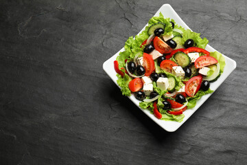 Delicious fresh Greek salad on black table, top view. Space for text