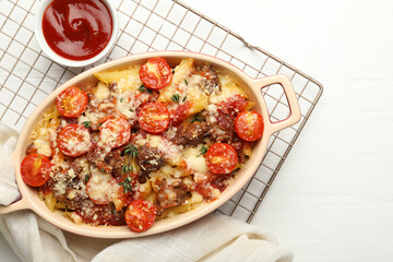 Delicious pasta casserole with cheese, tomatoes, minced meat and ketchup on white wooden table, flat lay
