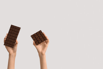 Female hands with sweet chocolate on white background