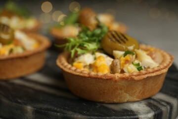 Tartlets with delicious filling on table, closeup. Bokeh effect