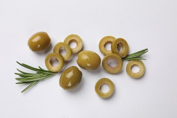 Marinated green olive rings, whole fruits and rosemary on white background, flat lay