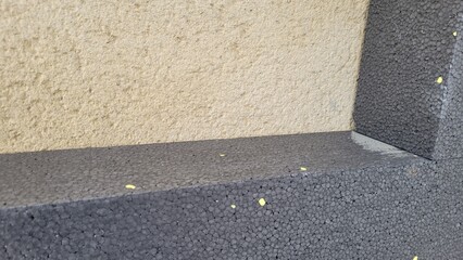 Morceau de polystyrène gris sur mur pour isolation ITE sur façade 
