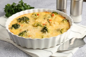 Delicious vegetable casserole and server on light table, closeup