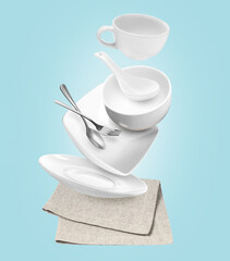 Clean dishware and silverware flying over napkin on light blue background