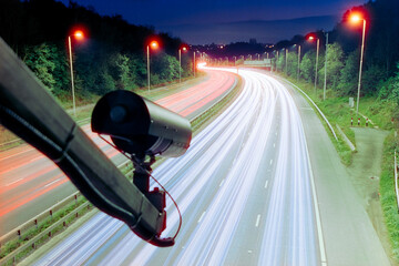 ANPR camera above a UK road, roadway, motorway, surveillance, light trails from moving traffic