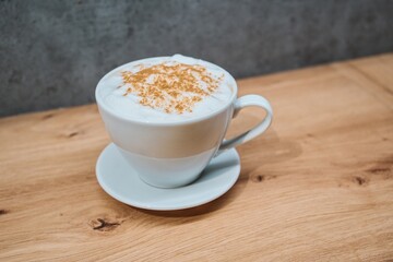 Cappuccino with Cinnamon on Wooden Table in Cozy Setting