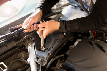 Auto mechanic working on car engine in his mechanic garage. Repair service. close up