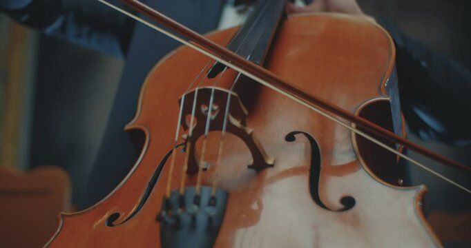 A closeup view of a skilled cellist passionately playing a beautifully captivating melody