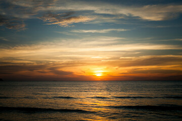 Fototapeta premium A tropical seaside beach during a stunning sunset, radiating a calm and peaceful atmosphere.
