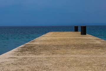 An empty concrete pier on the shore of the Adriatic Sea, a mooring place for small motorboats