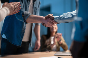 Fototapeta premium Business professionals shake hands in an office, sealing a successful agreement. A corporate meeting highlights teamwork, trust, and collaboration, welcoming a new employee and strengthening