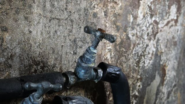 A mains cold water tap with condensation. Concept for price rises, water bills, and water meters. Static shot, 4K. Copy space.