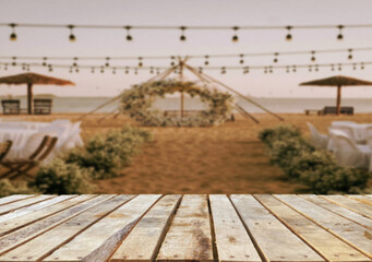 Wooden table top on blur restaurant or party wedding on the beach background.For montage product display or design key visual layout.View of copy space.
