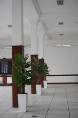 Pillars in an empty meeting room with meeting equipment and atrificial plants inside with a vintage concept