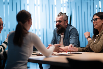 A diverse team of young professionals collaborates in a modern office conference room....