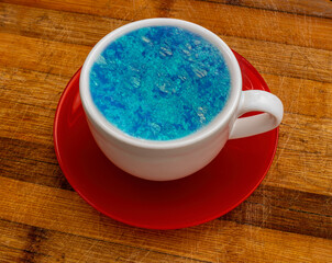 jouney in your cup, concept of summer season travel image with beautiful blue sea in a cup of tea or coffee