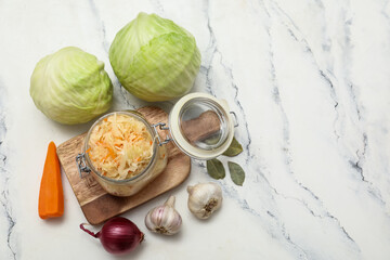 Jar of fermented cabbage and ingredients on table. Top view