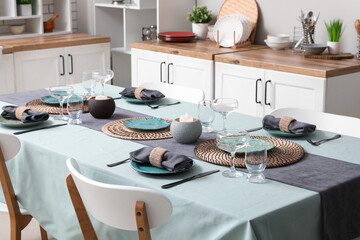 Table served for dinner with burning candles in kitchen. Closeup