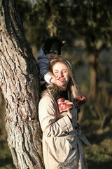 Happy family playing with paper planes in a blooming spring park with a city view