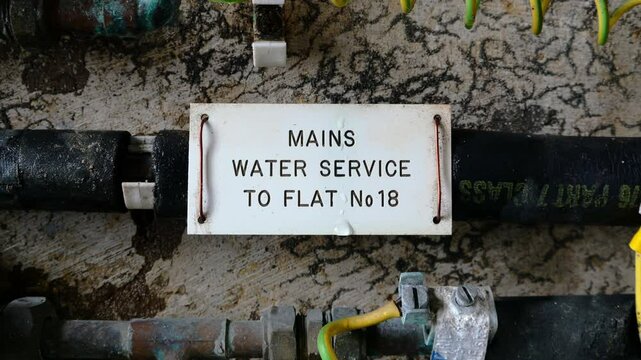 London, UK, March 1st 2025: A mains water pipe label, cold water supply to home. Concept for price rises, water bills, water meter and cost of living. Static shot, 4K.