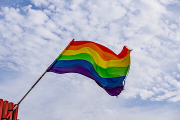 A rainbow flag is flying in the sky
