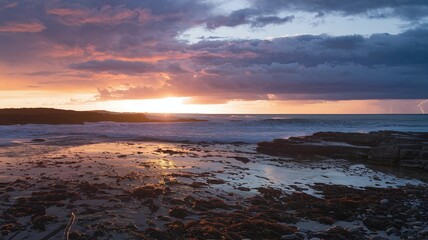 Sunset over rocky coastline with a dramatic stormy sky 