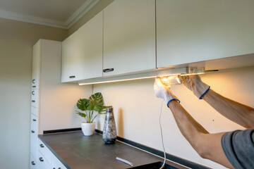 Installing under-cabinet lighting in a modern kitchen with stylish decor