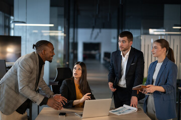 Diverse business team in discussion at a modern office, engaged in a professional meeting. Concept of teamwork, corporate collaboration, and workplace communication