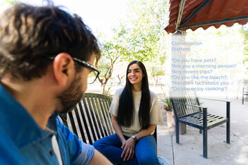 Man using augmented reality glasses displaying conversation starters while talking with a woman