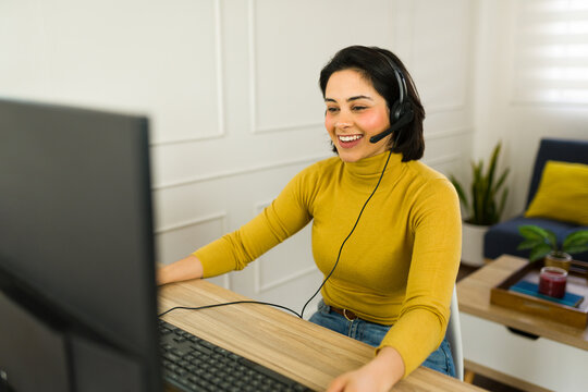 Professional customer service agent smiling while wearing headset, working efficiently from home office environment
