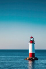 Fototapeta premium Lone lighthouse standing in calm blue ocean under a clear sky creating a serene and minimalistic maritime scene