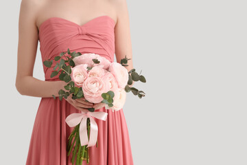 Young woman in dress with bouquet of beautiful ranunculus flowers on white background, closeup