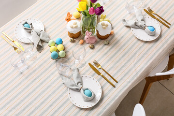 Tulip flowers, bunnies and eggs on table served for Easter celebration. Closeup