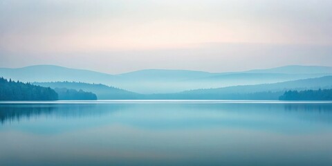 Serene lake reflecting misty mountains at dawn 