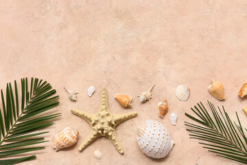 Sea shells with starfish and palm leaves on beige grunge background