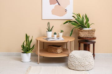 Interior of room with tables, pouf and green plants