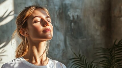 Fototapeta premium A woman enjoys sunshine with closed eyes and natural light