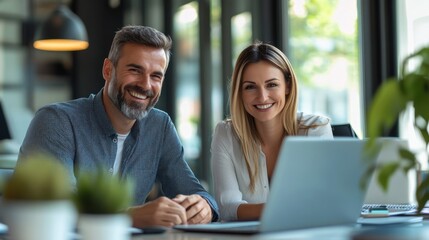 Man and woman at desk. People with laptop smiling. Workers at office happy. Teamwork and business concept. Positive workers looking at camera.